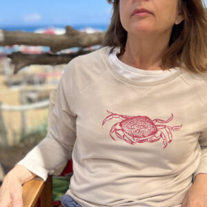 Frau trägt sandfarbenen Sweater mit Siebdruckmotiv Krabbe