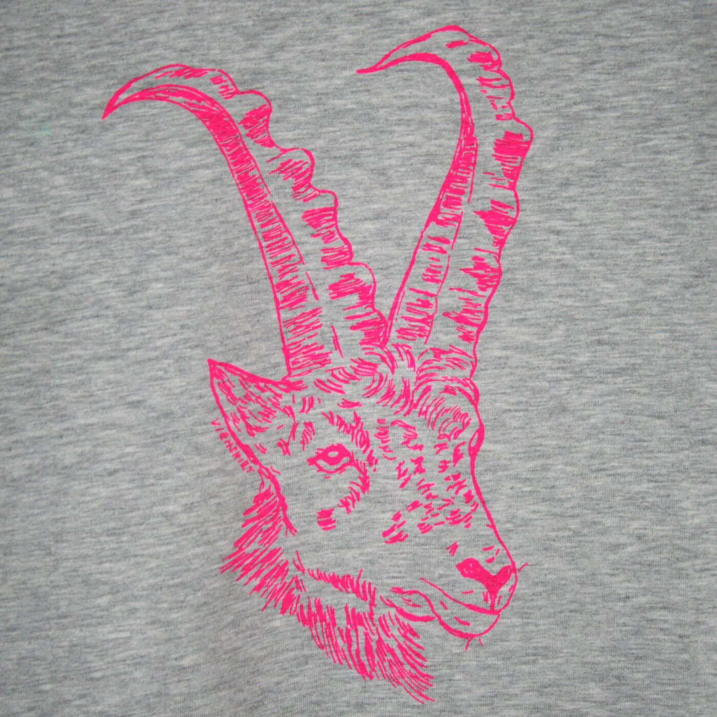 Detail eines graumelierten T-Shirts mit aufgedrucktem Steinbock-Kopf in neon-pink