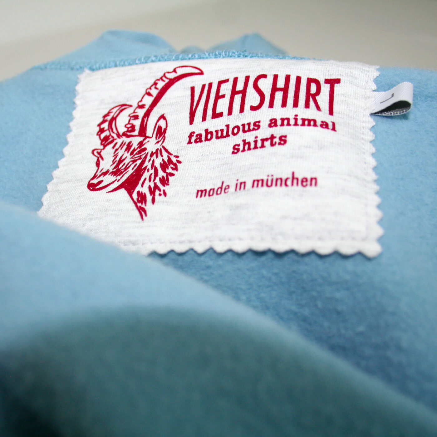 Detail des eingenähten Mode-Labels Viehshirt in einem flauschigen hellblauen Kleidungsstück