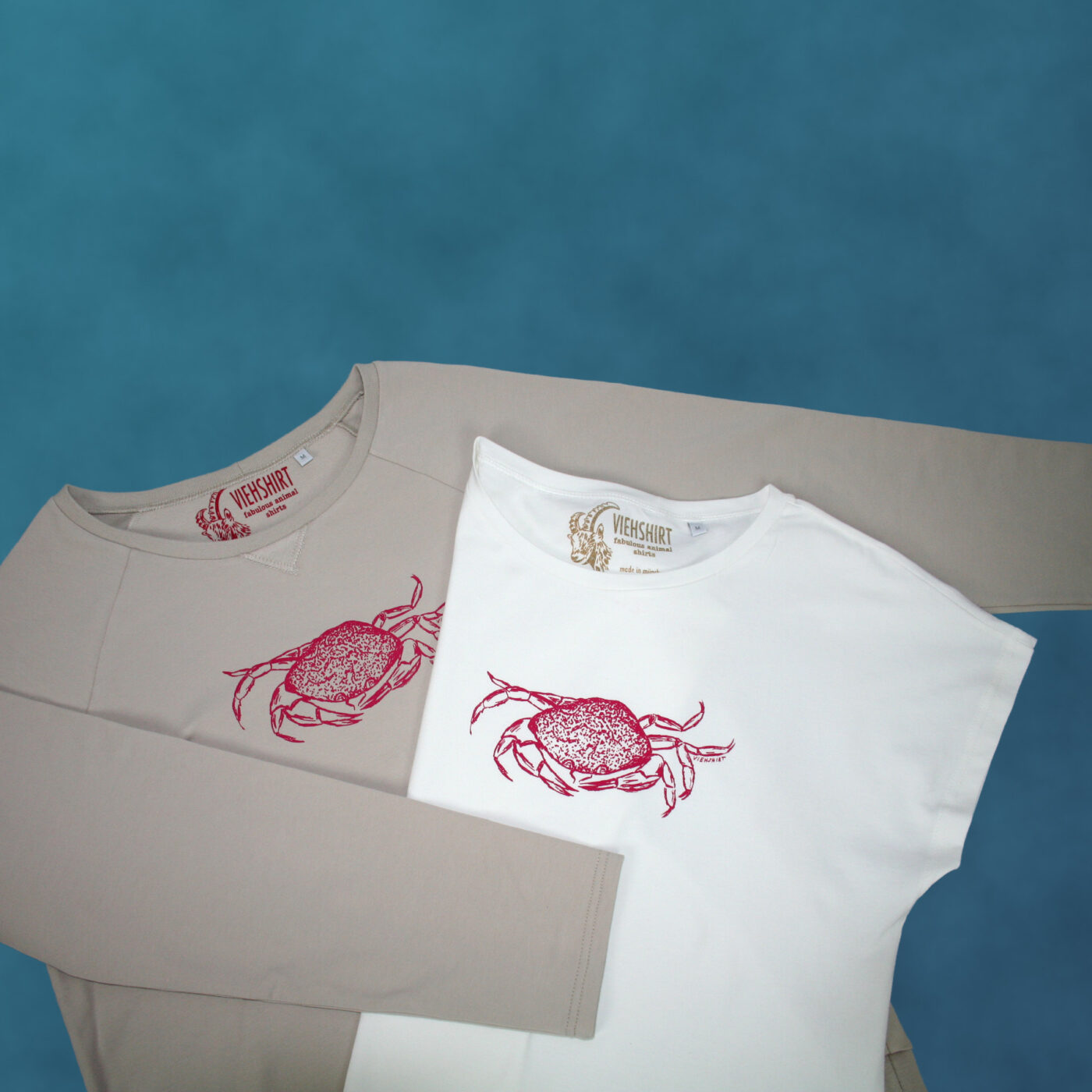 Sandfarbener Sweater und weißes T-Shirt, jeweils mit Siebdruckmotiv Krabbe