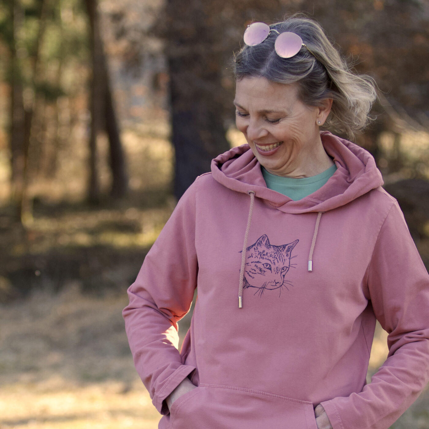 Frau trägt erdbeereisfarbenen Hoodie mit Katzen-Print