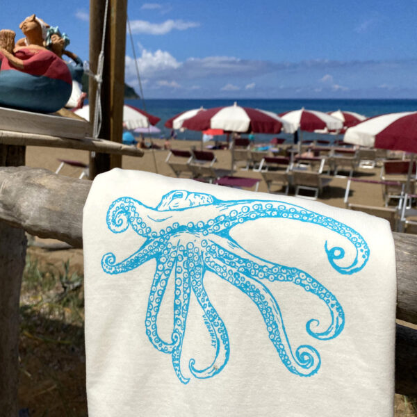 Weißes T-Shirt mit Siebdruckmotiv Oktopus hängt über Holzzaun